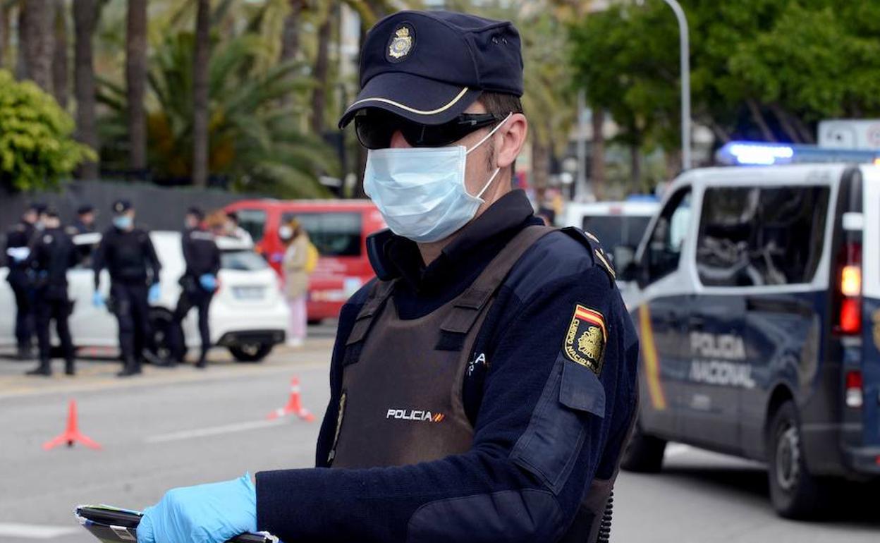 Un agente de la Policía Nacional con guantes y mascarilla. 