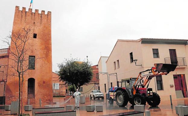 Un operarario realiza trabajos de desinfección con la ayuda de un tractor. 