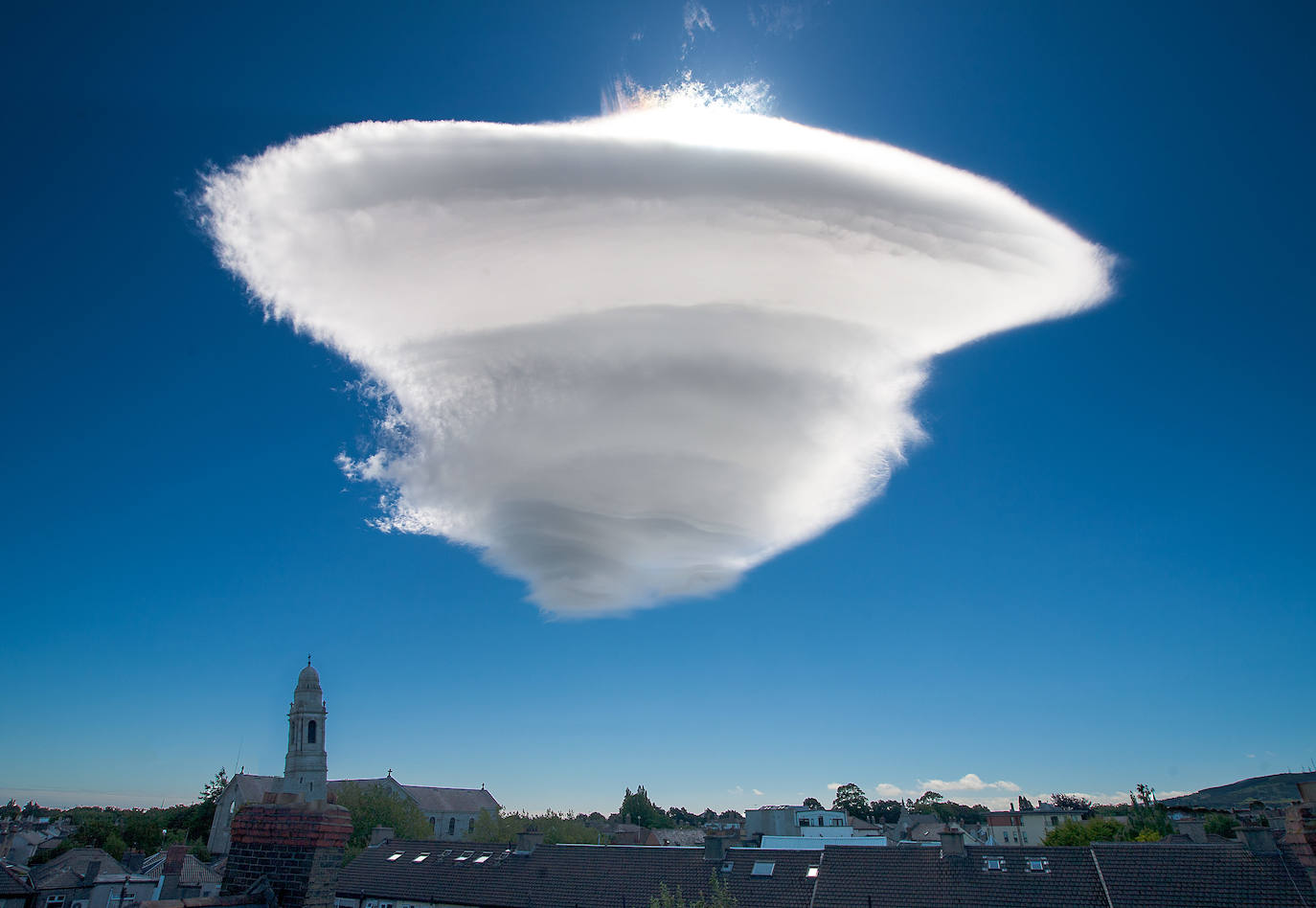 Nubes lenticulares | Se generan por los vientos descendientes de las montañas, donde estas nubes estacionarias con forma circular quedan aisladas de otras nubes a gran altitud. Aunque el viento sopla y desplaza el resto de nubes, estas se mantienen en el mismo lugar.