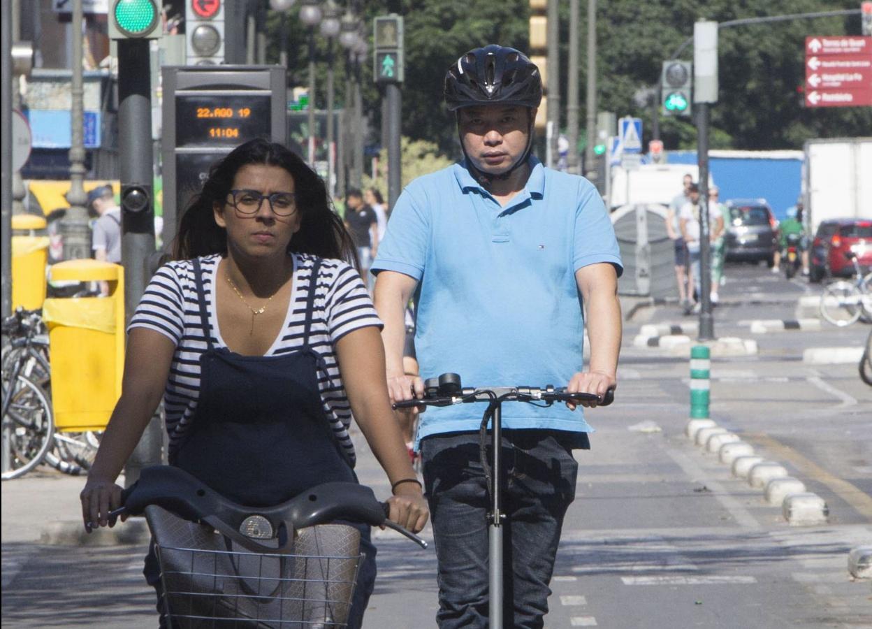 Una ciclista y un usuario de patinete, en Valencia. 