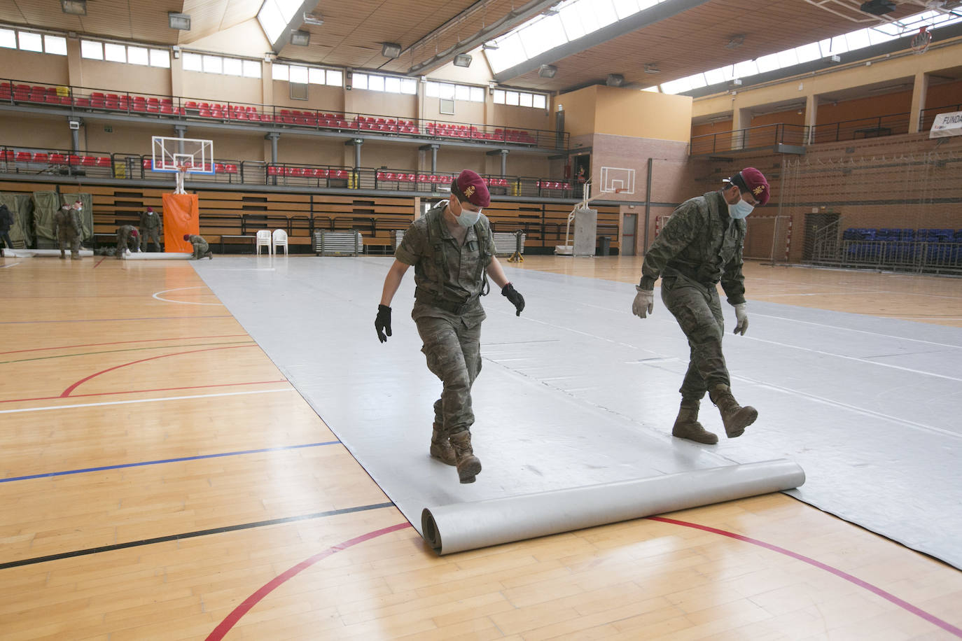 Militares del ejército colocan los materiales necesarios para adecuar el polideportivo del Cabanyal en un albergue para personas sin techo. 