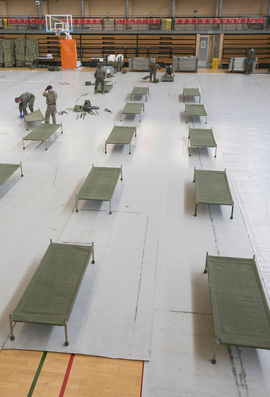 Militares del ejército colocan los materiales necesarios para adecuar el polideportivo del Cabanyal en un albergue para personas sin techo.