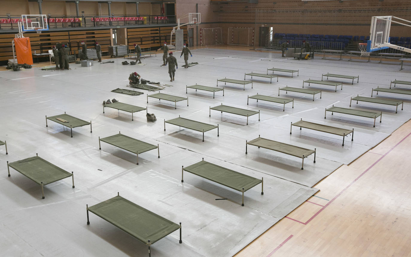 Militares del ejército colocan los materiales necesarios para adecuar el polideportivo del Cabanyal en un albergue para personas sin techo.