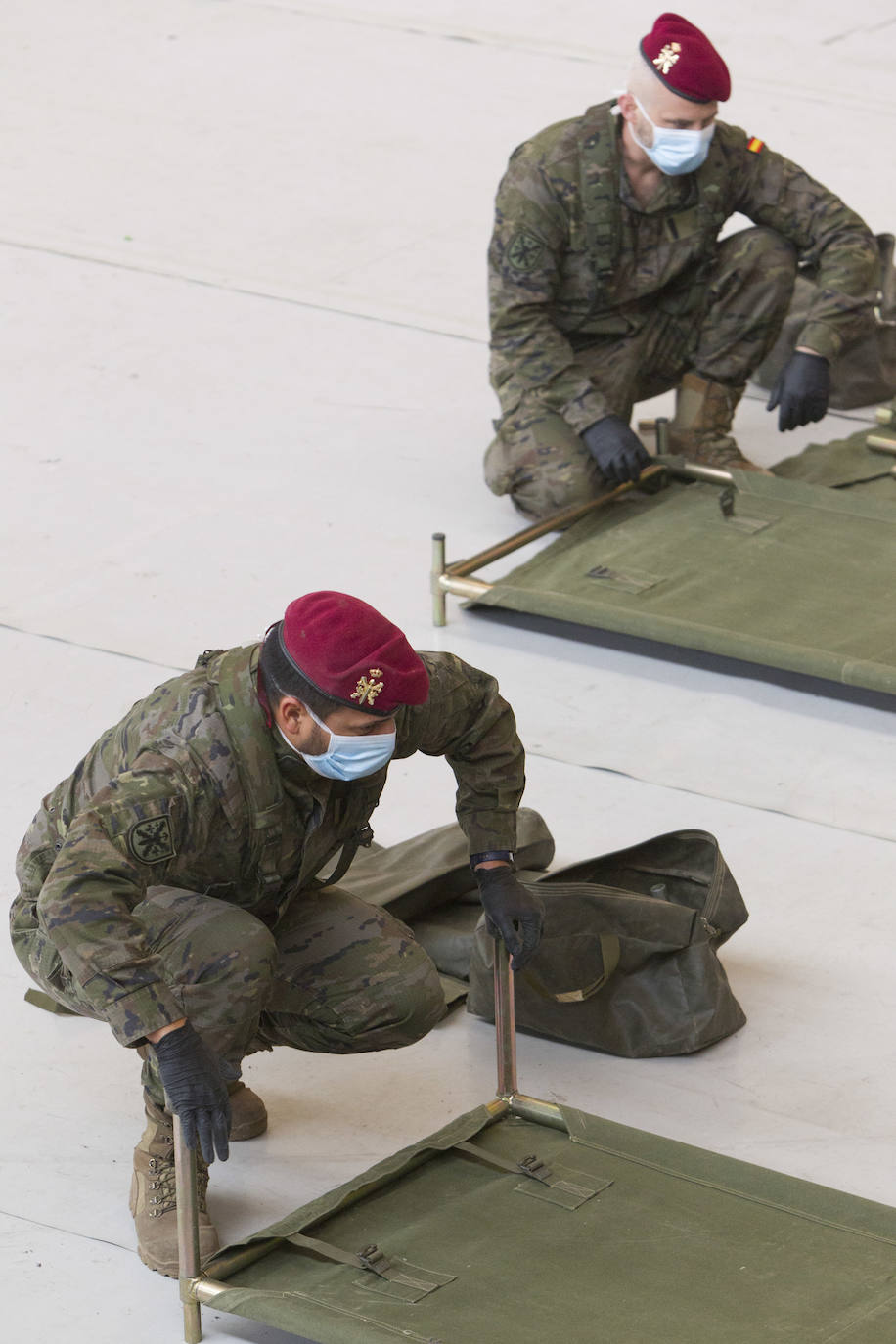 Militares del ejército colocan los materiales necesarios para adecuar el polideportivo del Cabanyal en un albergue para personas sin techo.