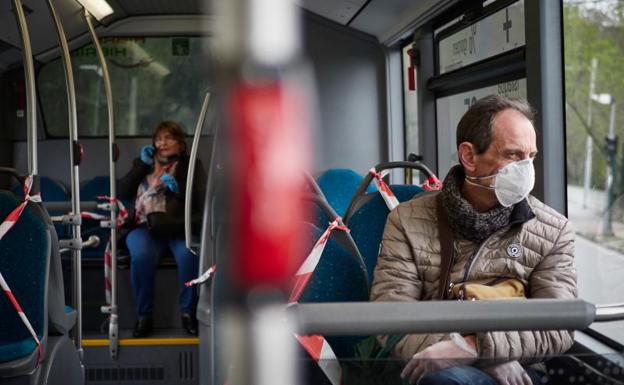 Un hombre protegido con una mascarilla viaja en un autobús urbano