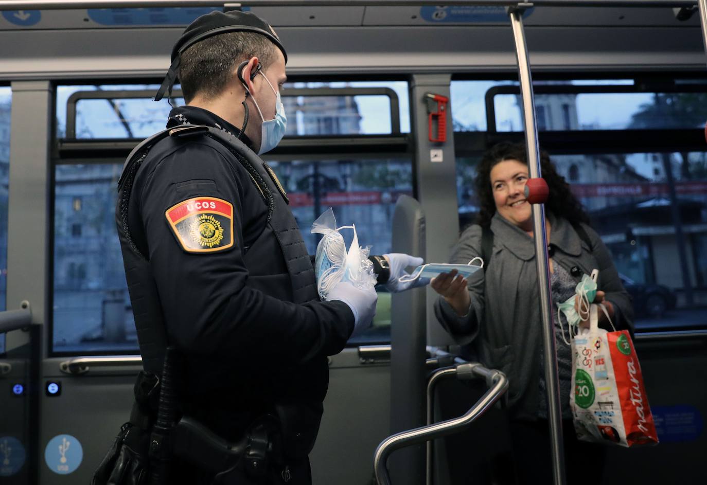 Policías y guardias civiles distribuyen mascarillas en estaciones de tren, cercanías, metros y autobuses a las personas que emplean el transporte público para acudir a sus puestos de trabajo en el primer día laborable tras la Semana Santa. 