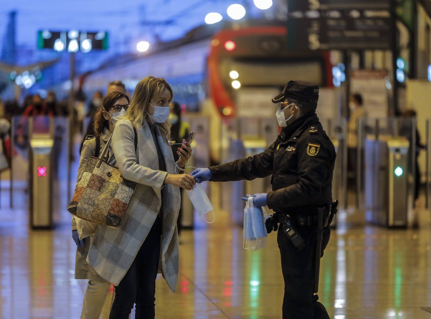 Policías y guardias civiles distribuyen mascarillas en estaciones de tren, cercanías, metros y autobuses a las personas que emplean el transporte público para acudir a sus puestos de trabajo en el primer día laborable tras la Semana Santa. 