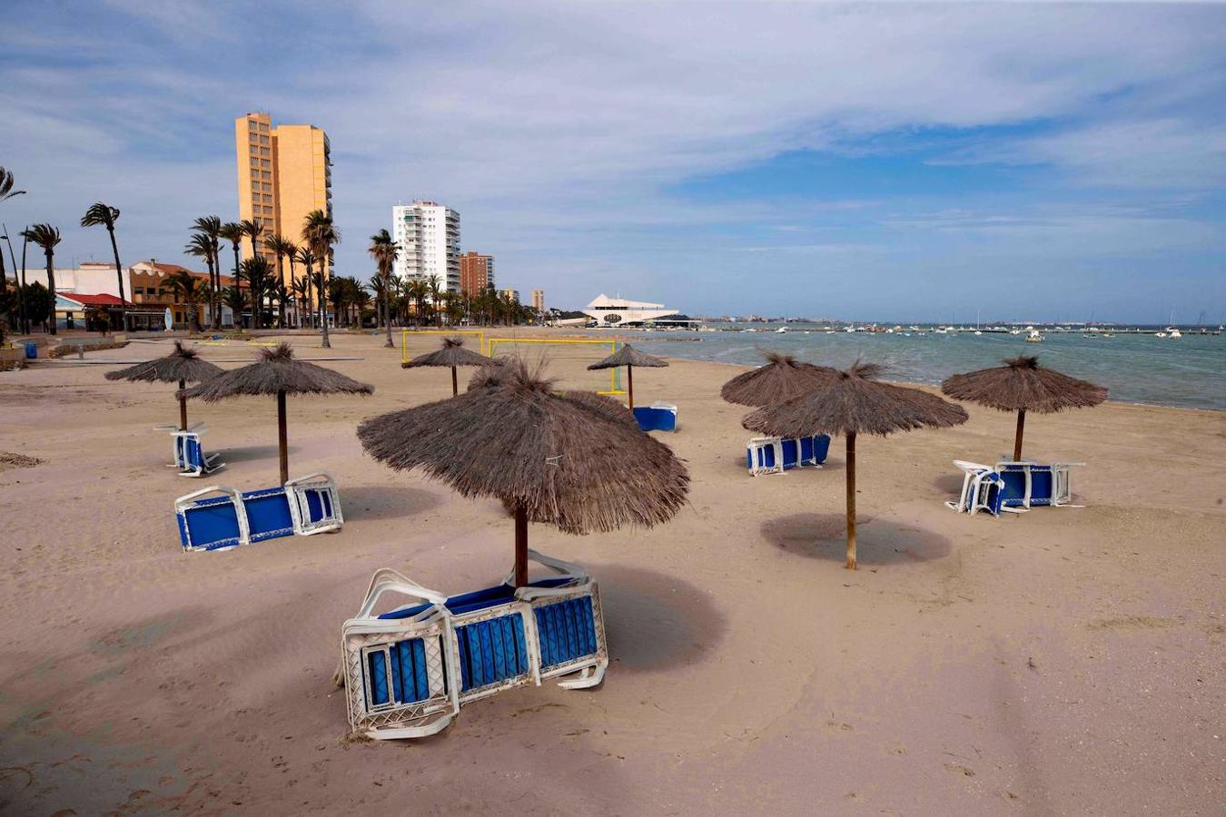 Sombrillas y hamacas en la playa desierta de Barnuevo, Santiago de la Ribera, Murcia. 