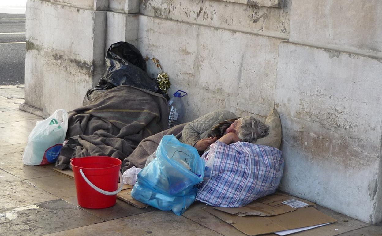 Un sin techo duerme en la calle.