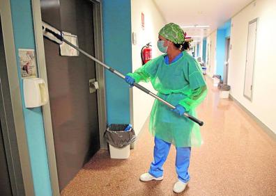 Imagen secundaria 1 - 1. Un paciente que ha salido de la UCI recibe los aplausos del personal sanitario en su camino a la planta. 2. El personal que realiza esta labor se ha convertido en una pieza clave para evitar que el virus pueda contagiar. La lejía diluida se usa de forma intensiva y metódica. 3. El calor de las protecciones y las agotadoras jornadas de trabajo dejan marcas en la piel de todo el personal que trabaja con enfermos infectados por el Covid. 