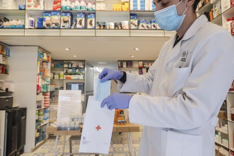 Una farmacia dispensa una mascarilla. 