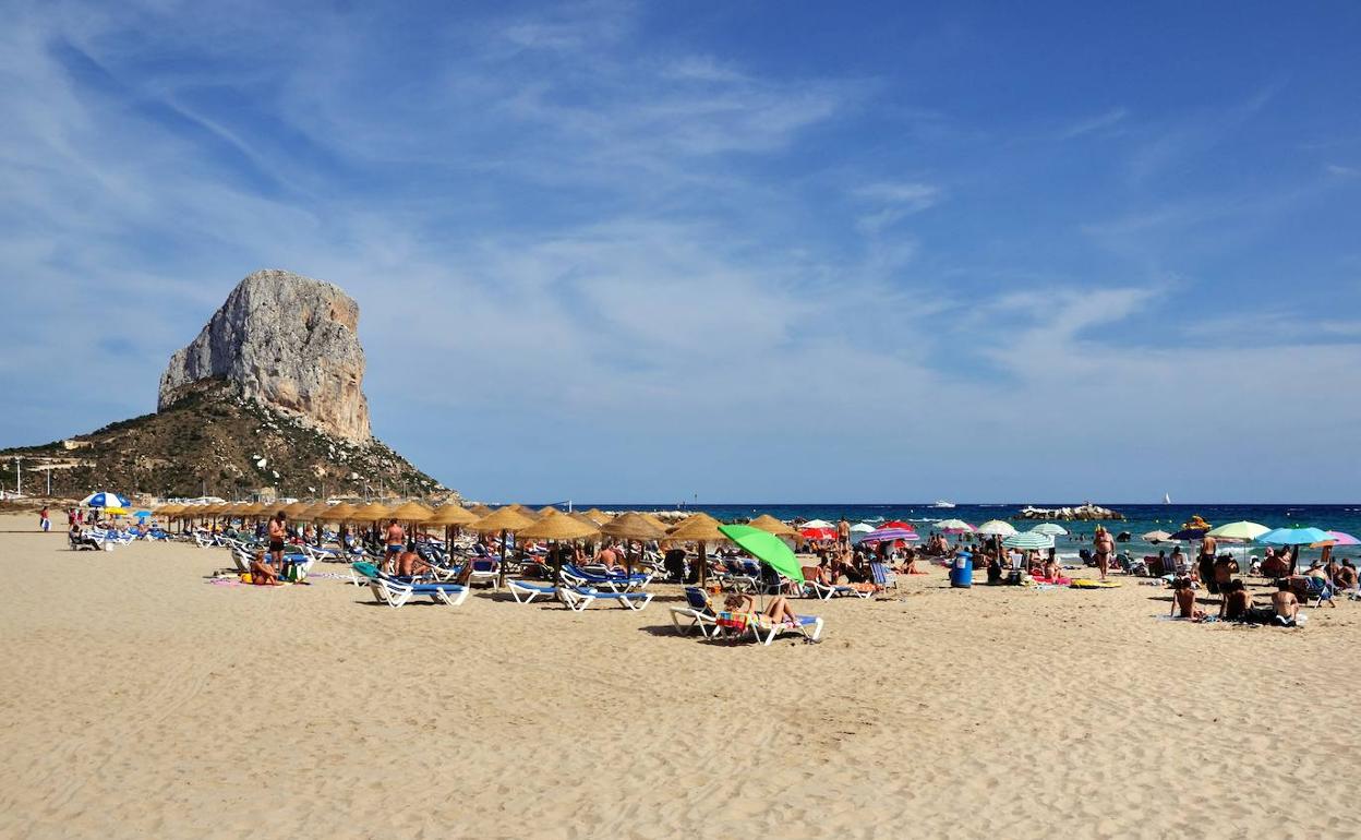 Decenas de personas disfrutan de un día de verano en la playa Arenal Bol de Calp.