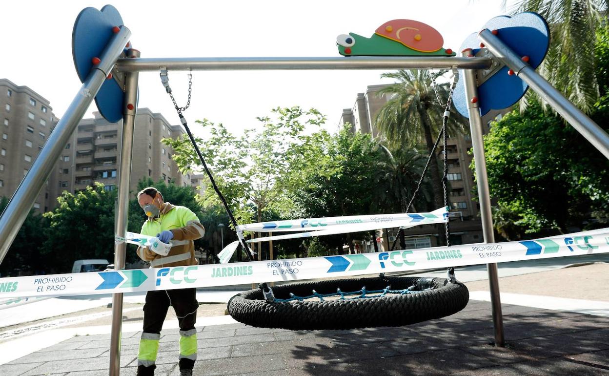 Un operario precinta un columpio en un parque de Valencia.