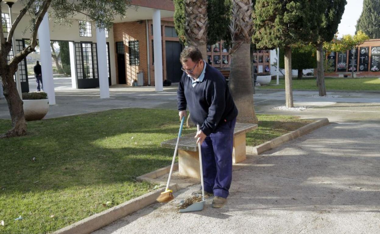 Un trabajador limpia el cementerio de Moncada. 