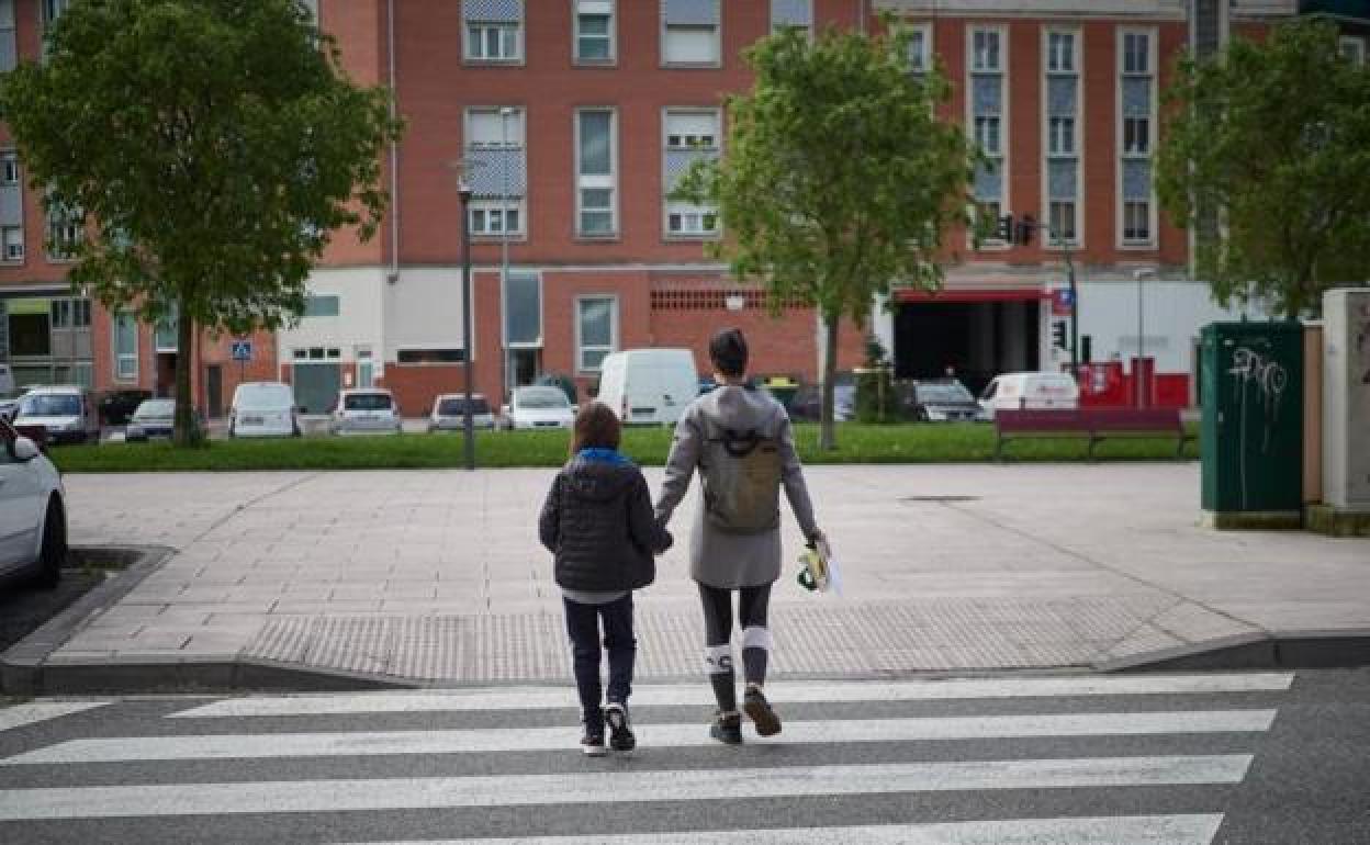 Una madre camina por la calle con su hija. 