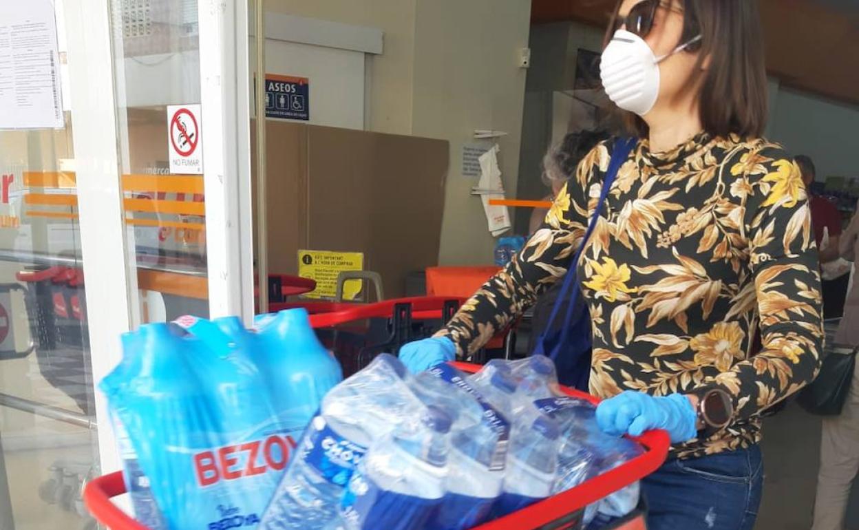 Una vecina cargada de agua a la salida de un supermercado de Xeraco. 