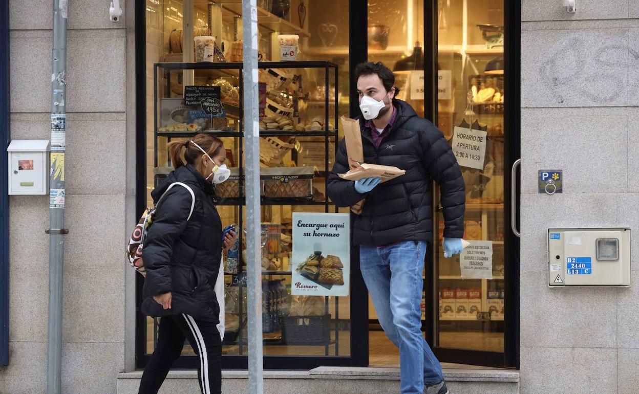 Dos personas en la calle con mascarillas. 