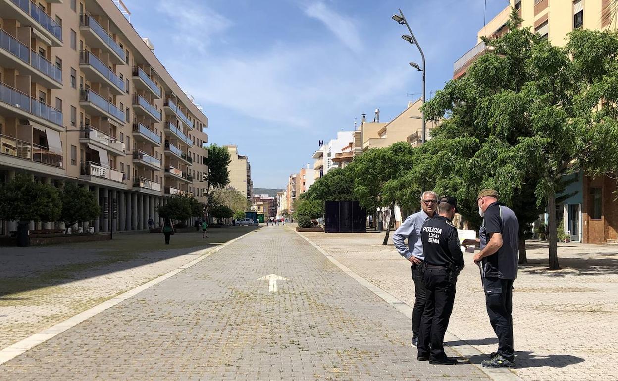 Un agente de la Policía Local y personal municipal comprobando el espacio en la calle La Vía para poner el mercado el viernes 