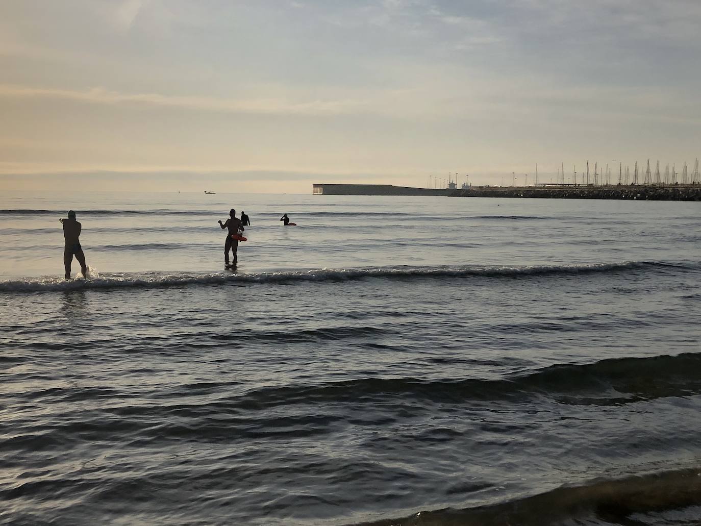 Nadadores, corredores, surfistas y personas practicando yoga se han dejado ver este jueves en las playas de Valencia desde que se ha asomado el sol, aprovechando las horas permitidas para practicar deporte en la ciudad. 