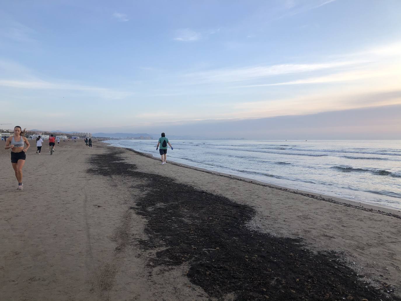 Nadadores, corredores, surfistas y personas practicando yoga se han dejado ver este jueves en las playas de Valencia desde que se ha asomado el sol, aprovechando las horas permitidas para practicar deporte en la ciudad. 