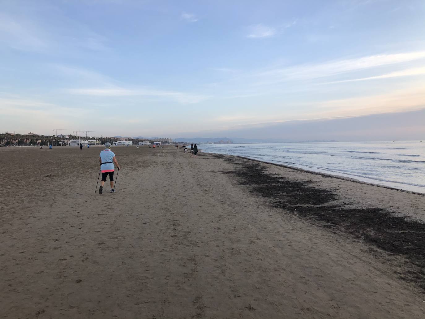 Nadadores, corredores, surfistas y personas practicando yoga se han dejado ver este jueves en las playas de Valencia desde que se ha asomado el sol, aprovechando las horas permitidas para practicar deporte en la ciudad. 