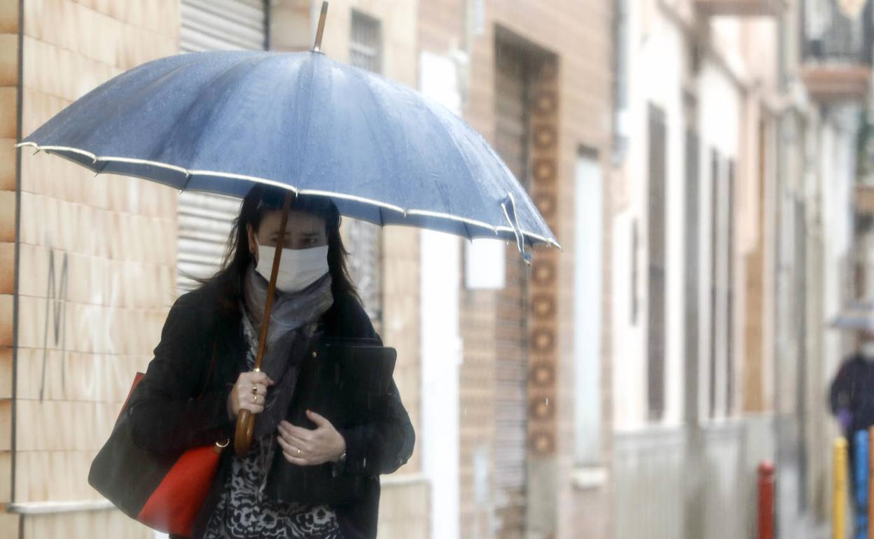 Una mujer se protege de la lluvia en Valencia