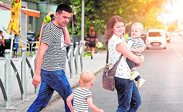 Una pareja pasea por la calle con sus hijos.