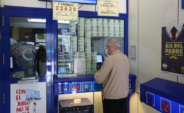 Un hombre sella su boleto en una administración de loteria. 