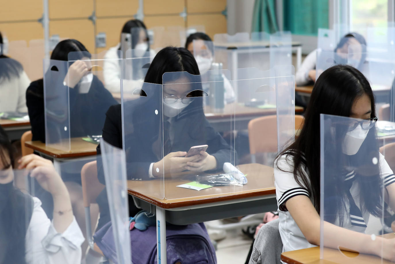 Corea del Sur, uno de los primeros países infectados por el coronavirus que surgió en la ciudad china de Wuhan, está recuperando poco a poco la normalidad. Muestra de ello ha sido el regreso a las clases de sus estudiantes. Los primeros en volver a los pupitres han sido los alumnos de bachillerato; el resto se irá incorporando poco a poco. No obstante, el inicio del curso escolar se ha hecho con una serie de medidas para evitar los contagios entre los estudiantes: el uso de mascarillas en todo momento, limpieza de los pupitres, ventilación continua de los cuartos, mámparas en el comedor y en las mesas y tomas de temperatura al entrar al colegio, todo ello, manteniendo las distancias de seguridad. 