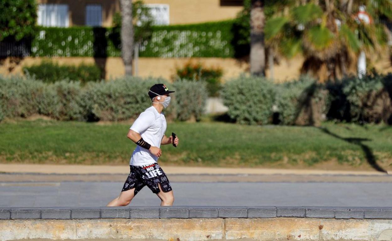 Un hombre hace deporte con la mascarilla puesta.