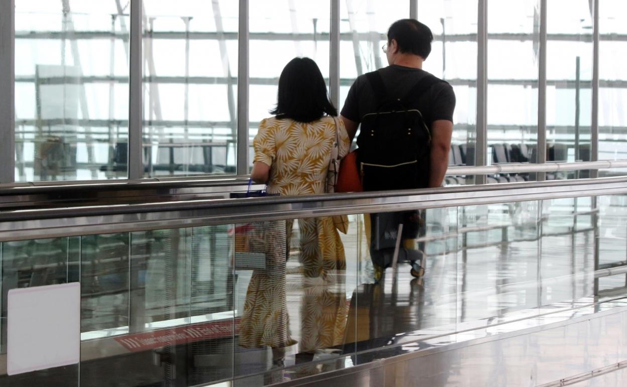 Dos pasajeros en un aeropuerto.