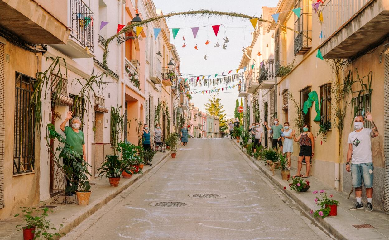 Residentes de Potries en una de las calles, junto a la decoración elaborada. 