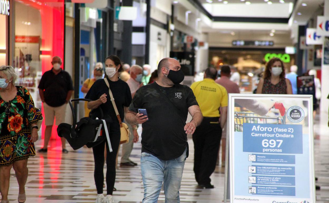 Clientes del centro comercial de Ondara circulan por las instalaciones con mascarilla.