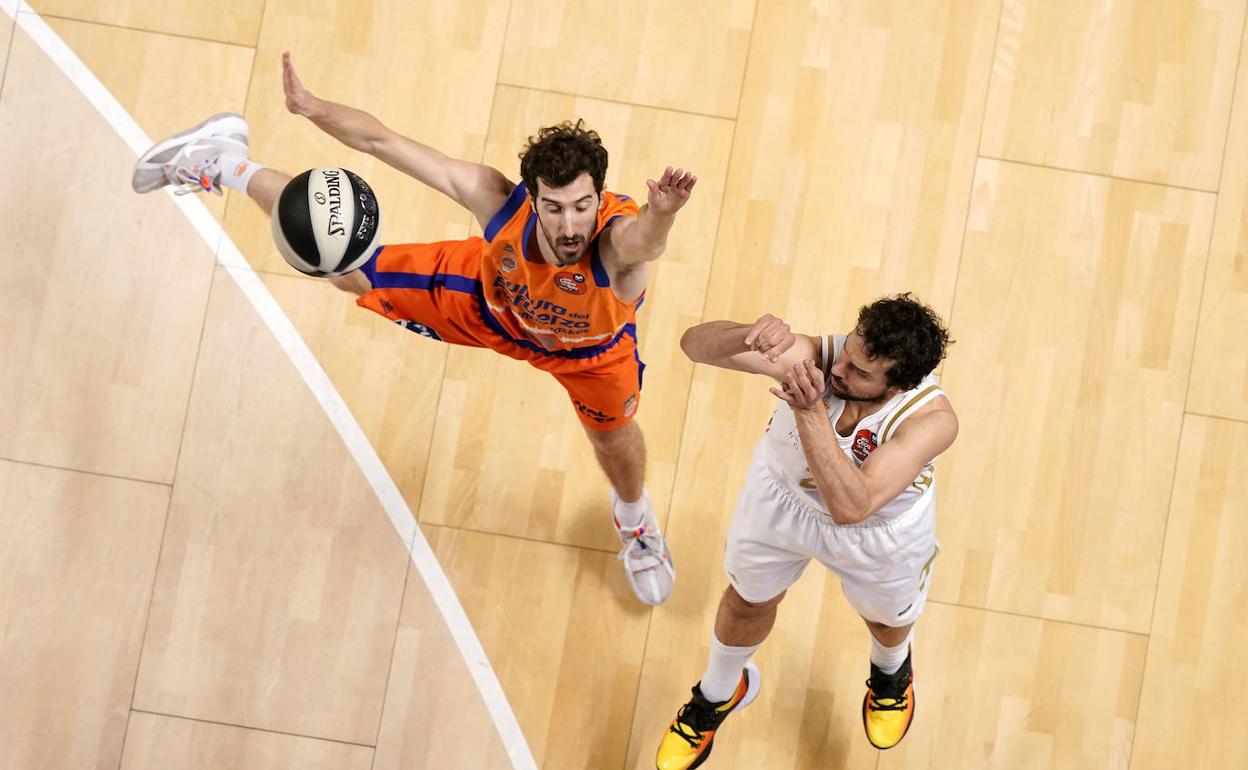 Guillem Vives intenta taponar un triple de Llull. 