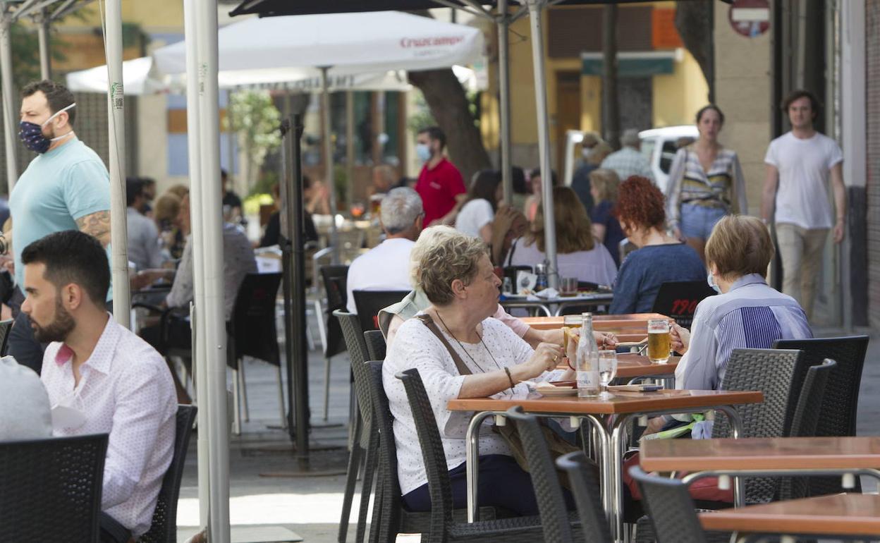 Varias personas disfrutan de las terrazas de la zona del Mercado Central de Valencia. 