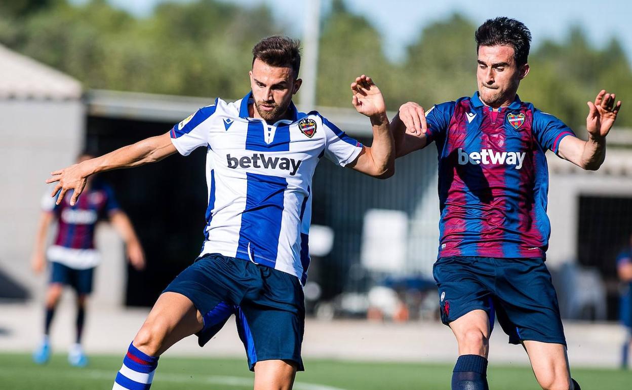 Mayoral y Postigo pelean por el balón durante el partido de esta tarde en Buñol.