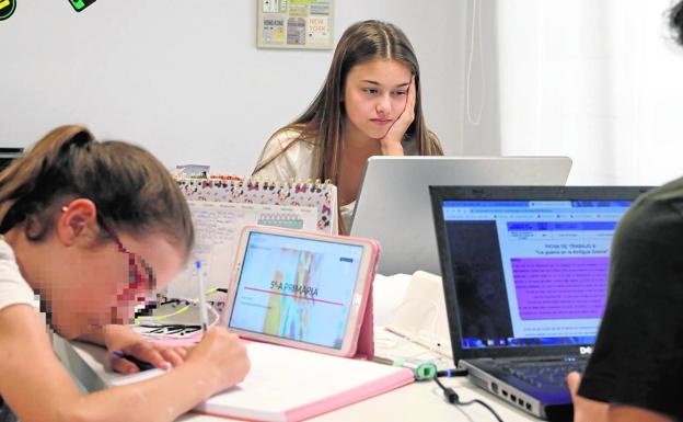 Imagen principal - Los hermanos Mar, AMparo y Santi haciendo sus tareas. | Quique Martínez, alumno de 4º de la ESO, trabajando con su portátil.