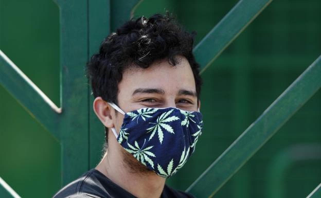 Un joven con una mascarilla de tela.