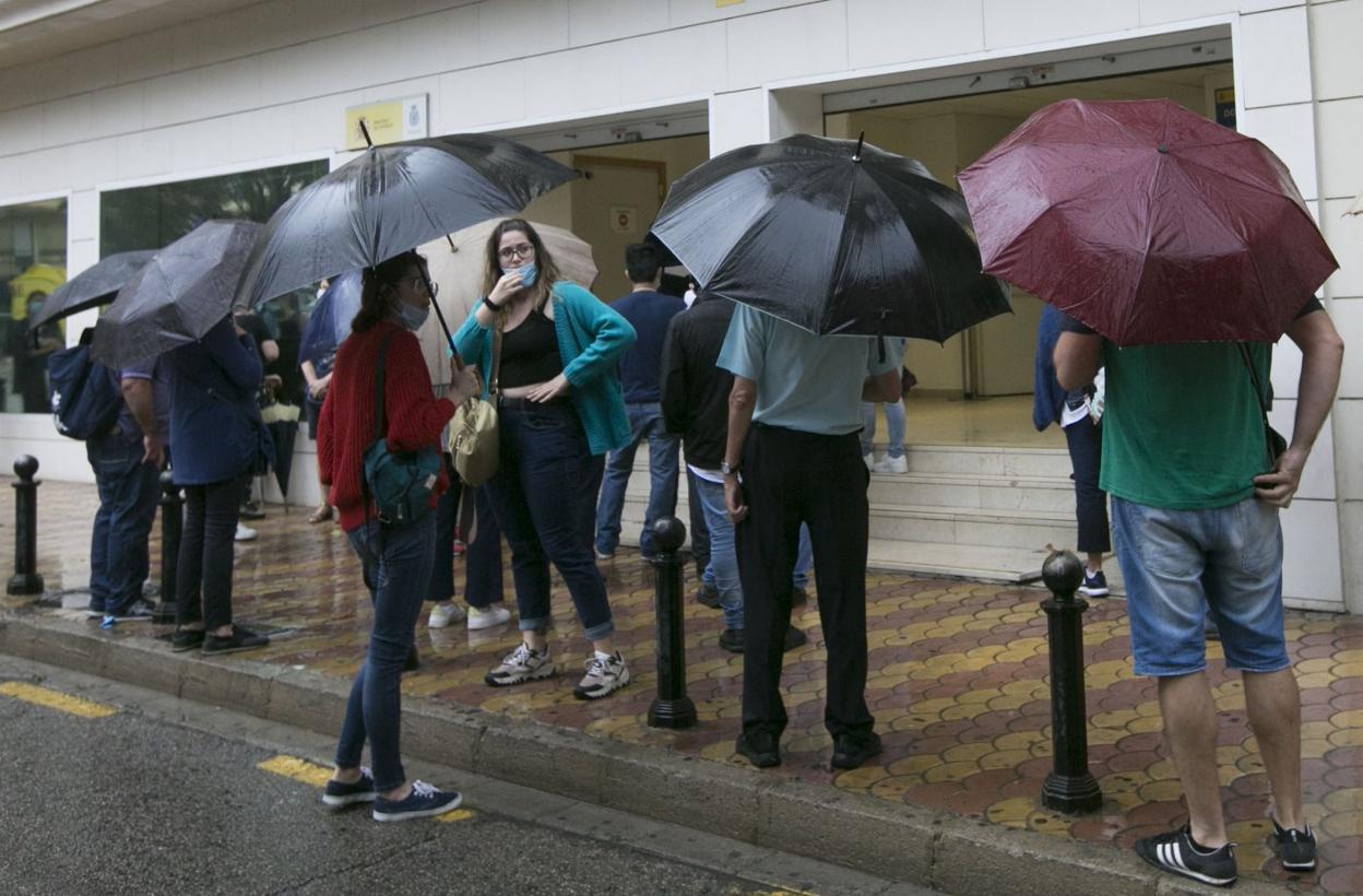 Colas de ciudadanos para los trámites del DNI y pasaporte, ayer, en la calle Hospital. damián torres