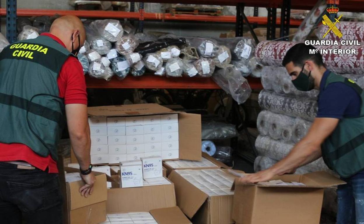 Agentes en la nave de la empresa con las mascarillas que estaban en cajas sin sello. 