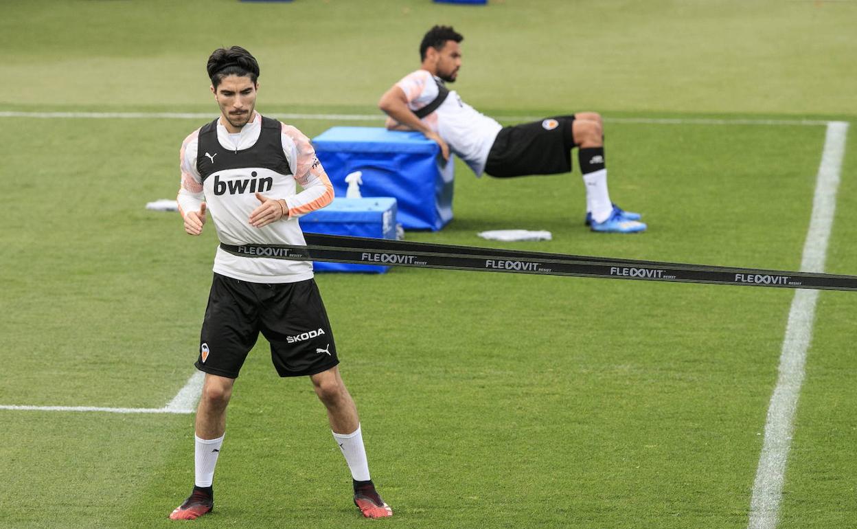 Carlos Soler, en Paterna, realizando ejercicios de fuerza, detrás, Francis Coquelin. 