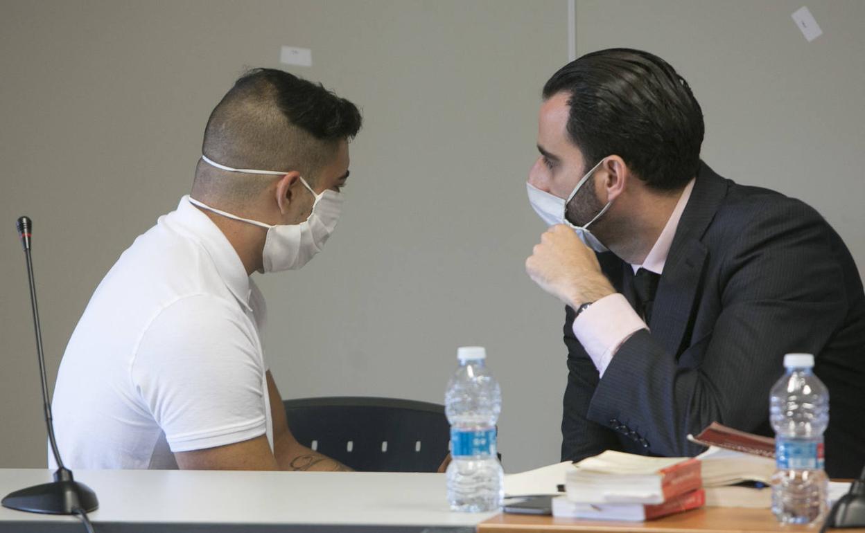 El acusado dialoga con un abogado de la defensa poco antes del arranque del juicio, ayer, en Valencia. 