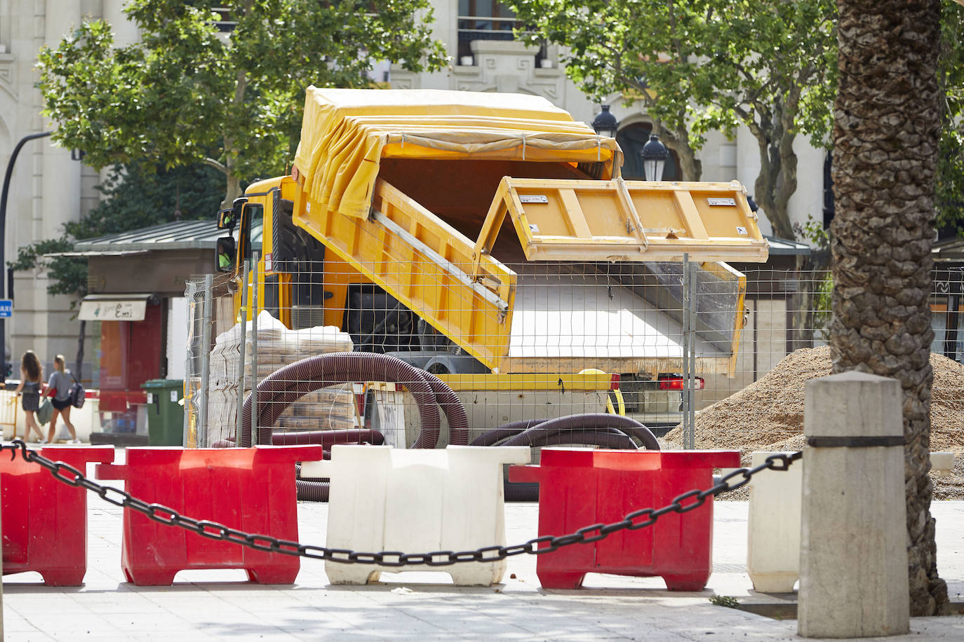 El nuevo asfalto rojizo de la plaza del Ayuntamiento ya está terminado en el tramo frente al teatro Rialto, cerca de la esquina con la calle Barcelonina, por lo que es la imagen más fidedigna de cómo quedará la plaza cuando terminen las obras, que se espera que finalicen en días. 