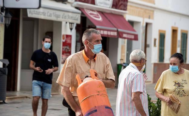 Varias personas con mascarillas quirúrgicas en la calle. 