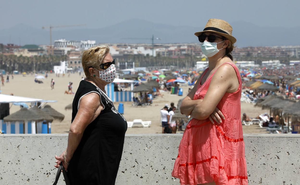 Dos mujeres frente a la playa de las Arenas en Valencia. 