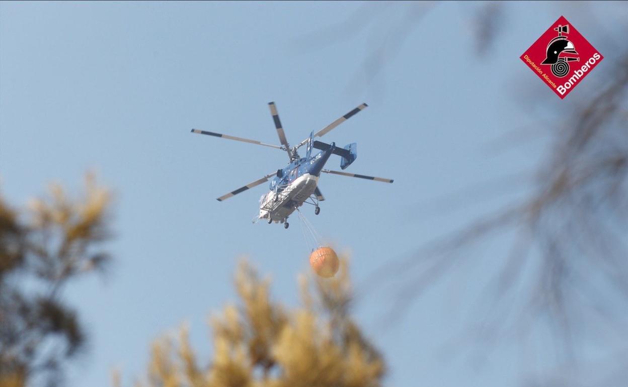 Un helicóptero trabaja en las tareas de extinción del incendio.