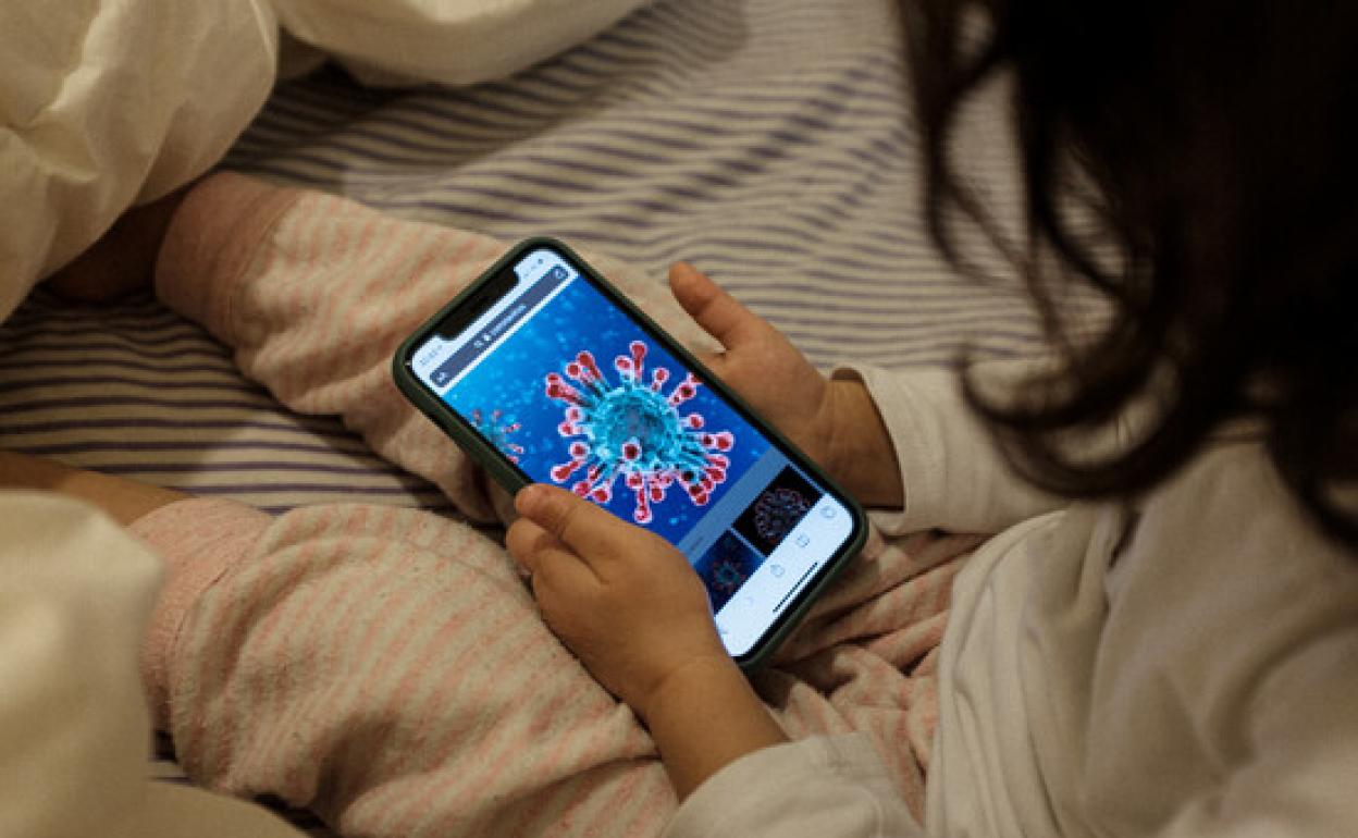 Una niña de dos años juega con el teléfono móvil 