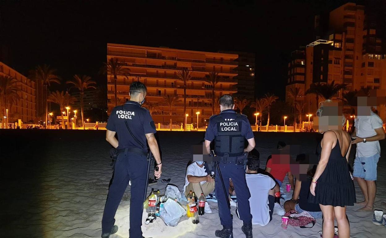 Dos agentes de la Policía Local denuncian a unos jóvenes por realizar un botellón en la playa de San Juan la pasada madrugada. 