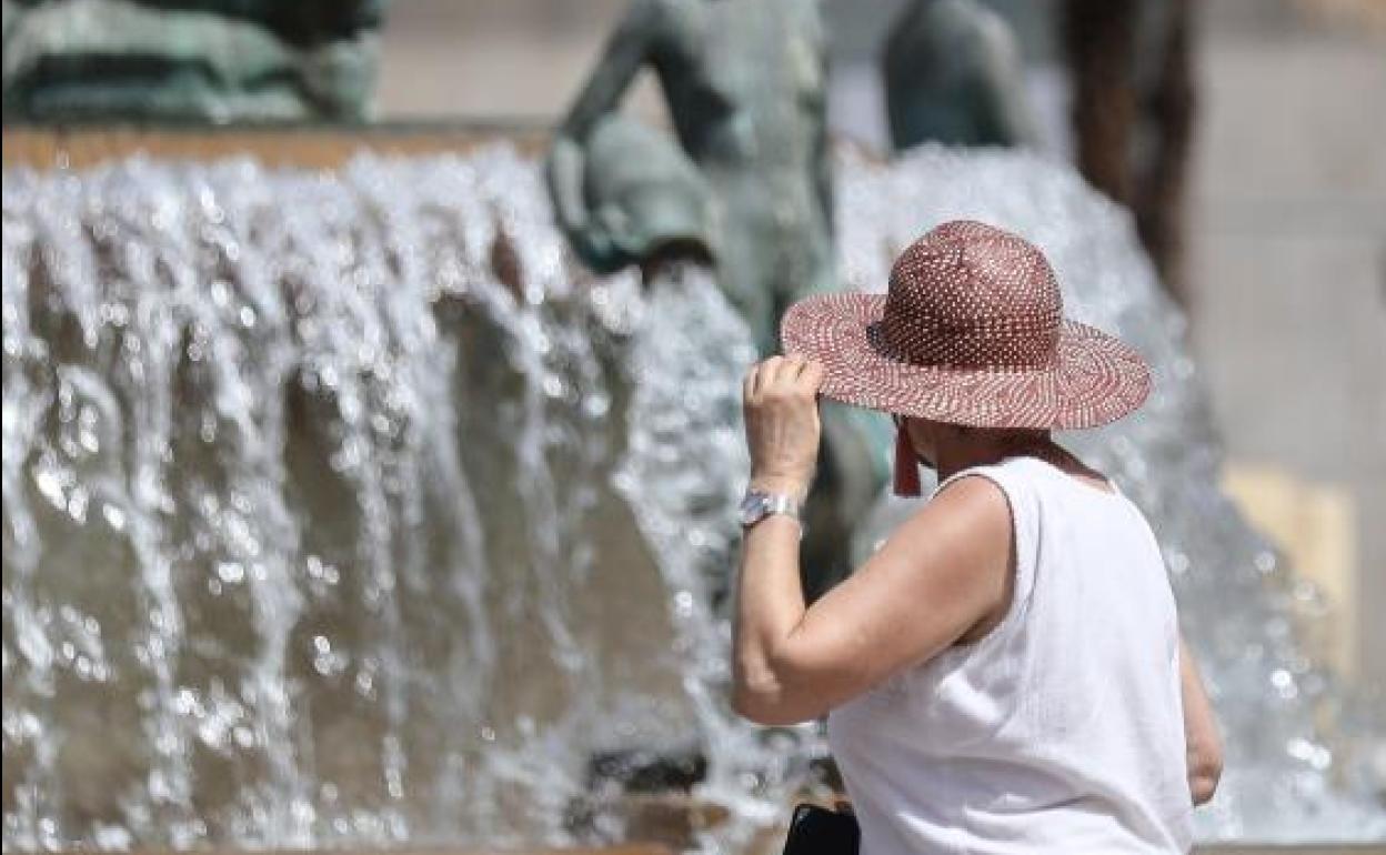 Una mujer se protege del calor en el centro histórico de Valencia.