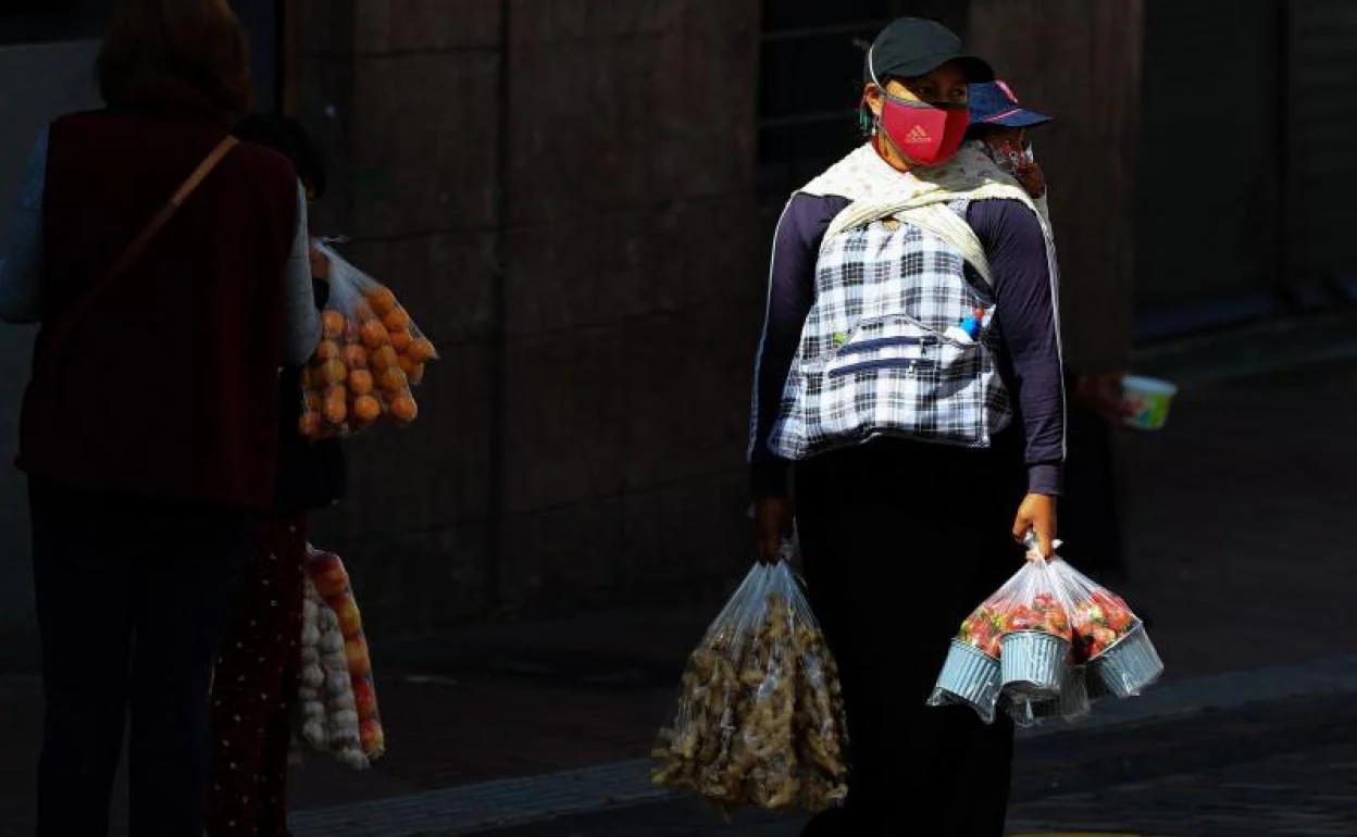 Una vendedora informal vende sus productos en la calle hoy jueves en Quito (Ecuador)